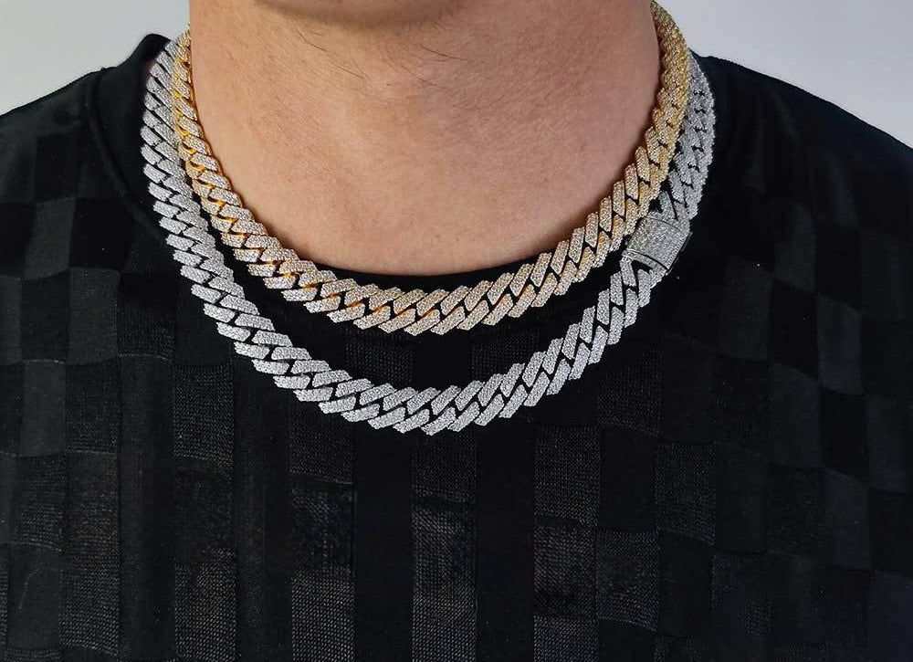Gold- and silver-tone iced Cuban link chains worn over a black shirt