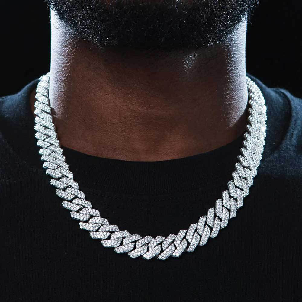Man wearing a wide iced Cuban link chain over a black shirt