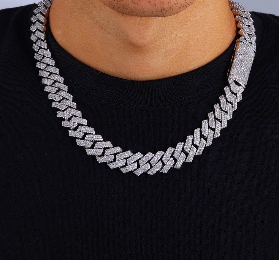 Two silver-tone iced Cuban link chains worn over a black shirt