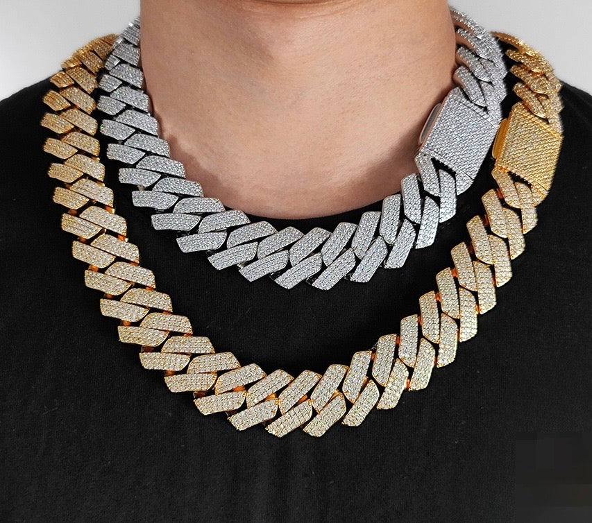 Gold- and silver-tone 25mm iced Cuban link chains worn over a black top