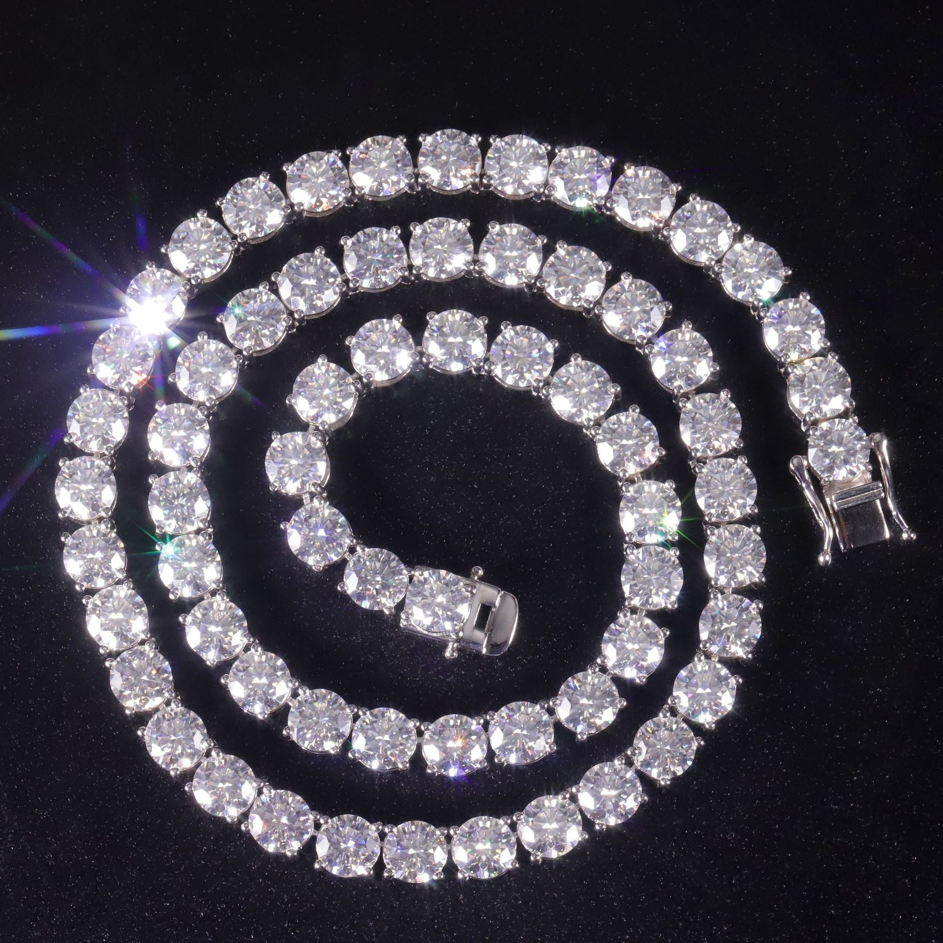 Silver-tone moissanite tennis chain arranged in a circle on a black background