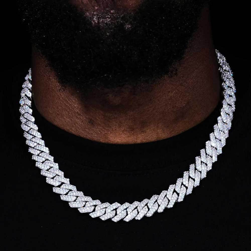 Man wearing a wide silver-tone iced Cuban link chain over a black shirt