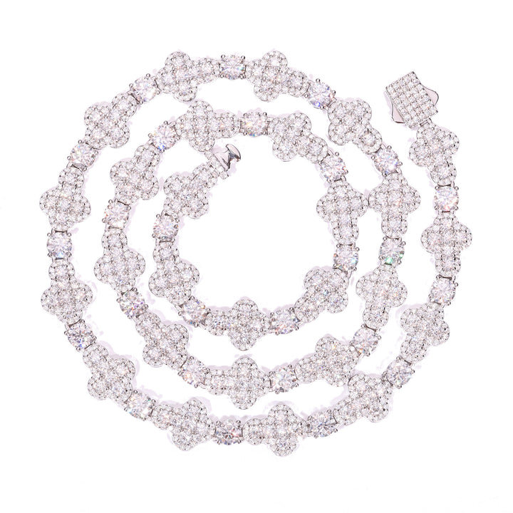 Silver-tone moissanite cross tennis chain coiled on a white background