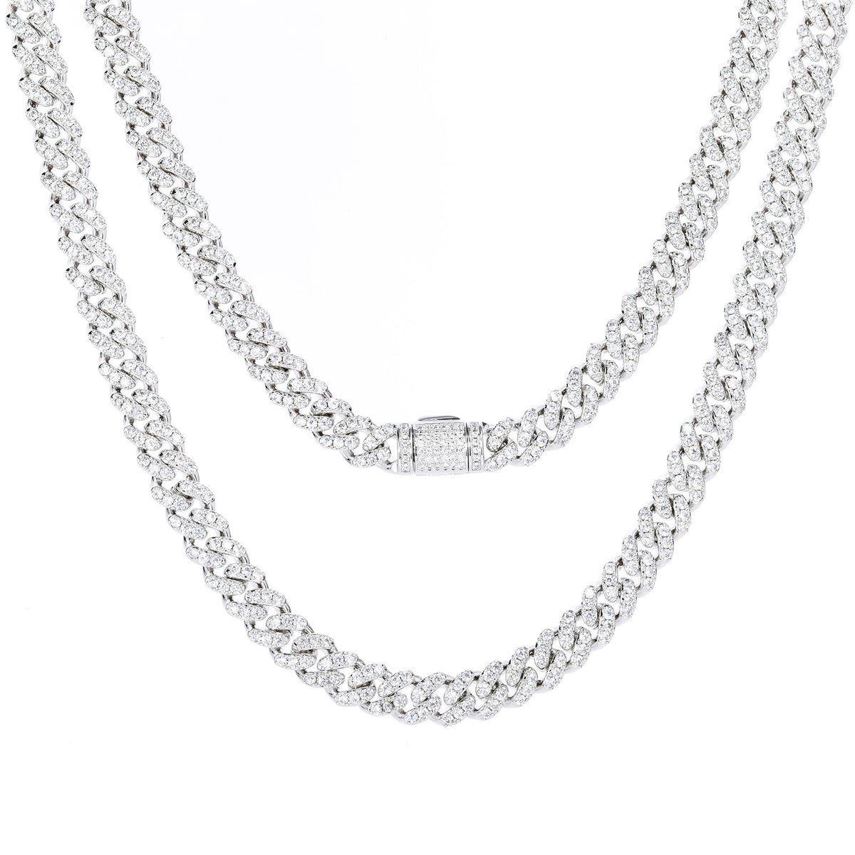 Two silver-tone moissanite Cuban chains draped on white, with a stone-set clasp