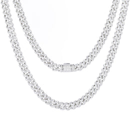 Two silver-tone moissanite Cuban chains draped on white, with a stone-set clasp