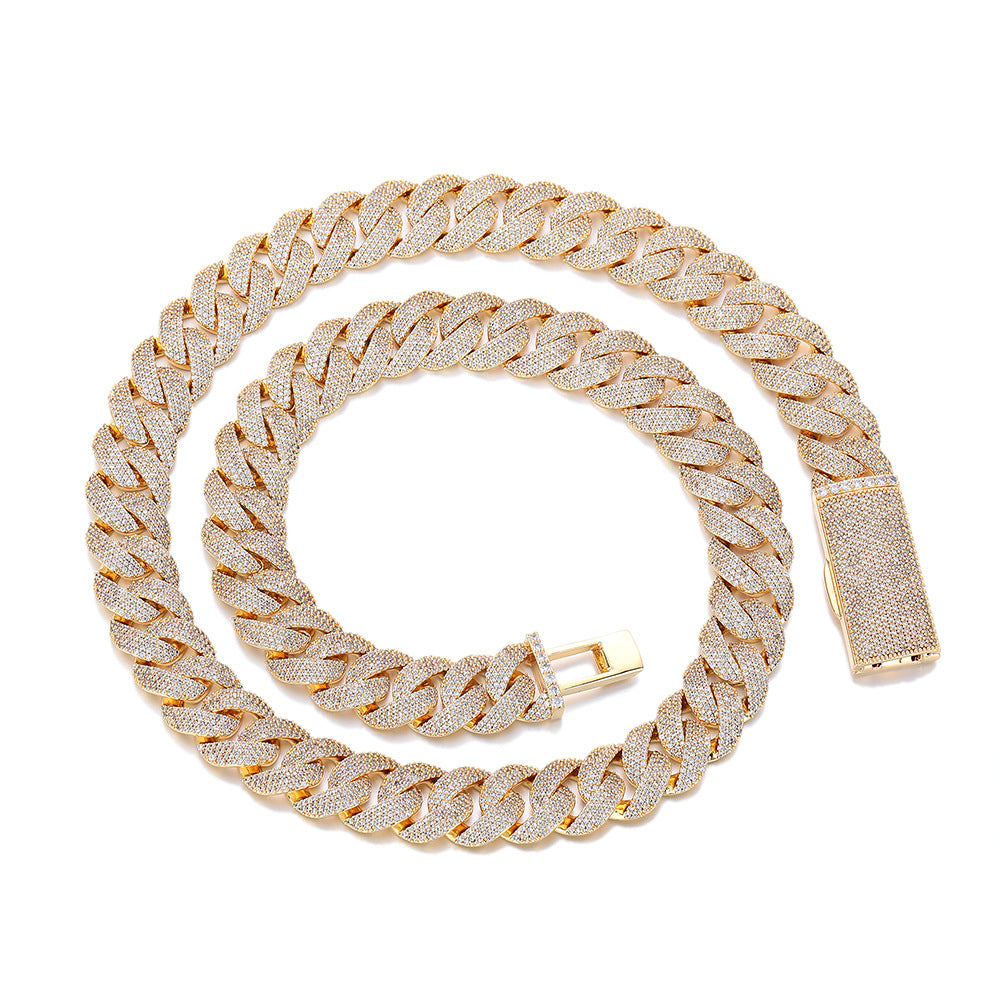 Gold-tone pavé Cuban chain coiled on white with its box clasp open