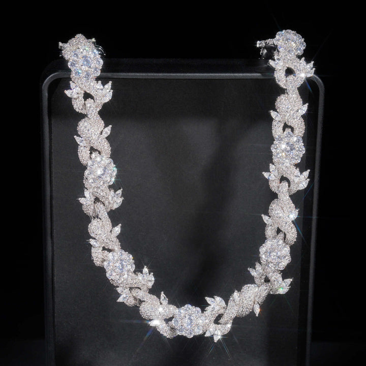 Silver-tone flower-link necklace arranged against black