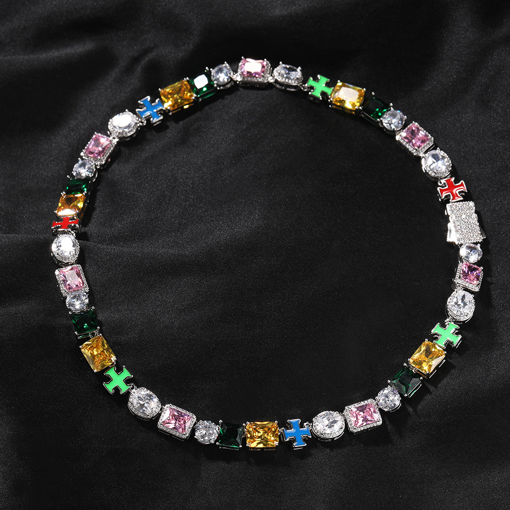 Multicolor cross link necklace arranged in a circle on black fabric