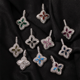 Ten silver-tone colored four-leaf clover pendants arranged on black fabric
