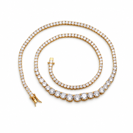 Gold-tone graduated tennis necklace coiled on white with its clasp open