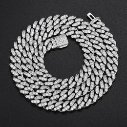Silver-tone single-row moissanite Cuban chain coiled on black fabric with an open clasp