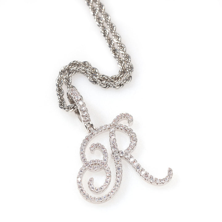 Silver-tone cubic zirconia script letter R pendant on white