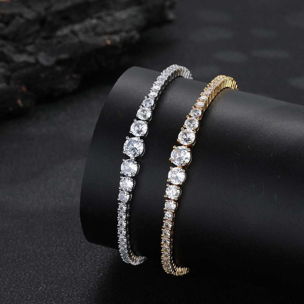 Silver- and gold-tone graduated tennis bracelets on a black display
