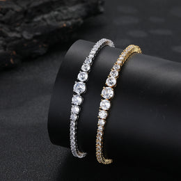 Silver- and gold-tone graduated tennis bracelets on a black display