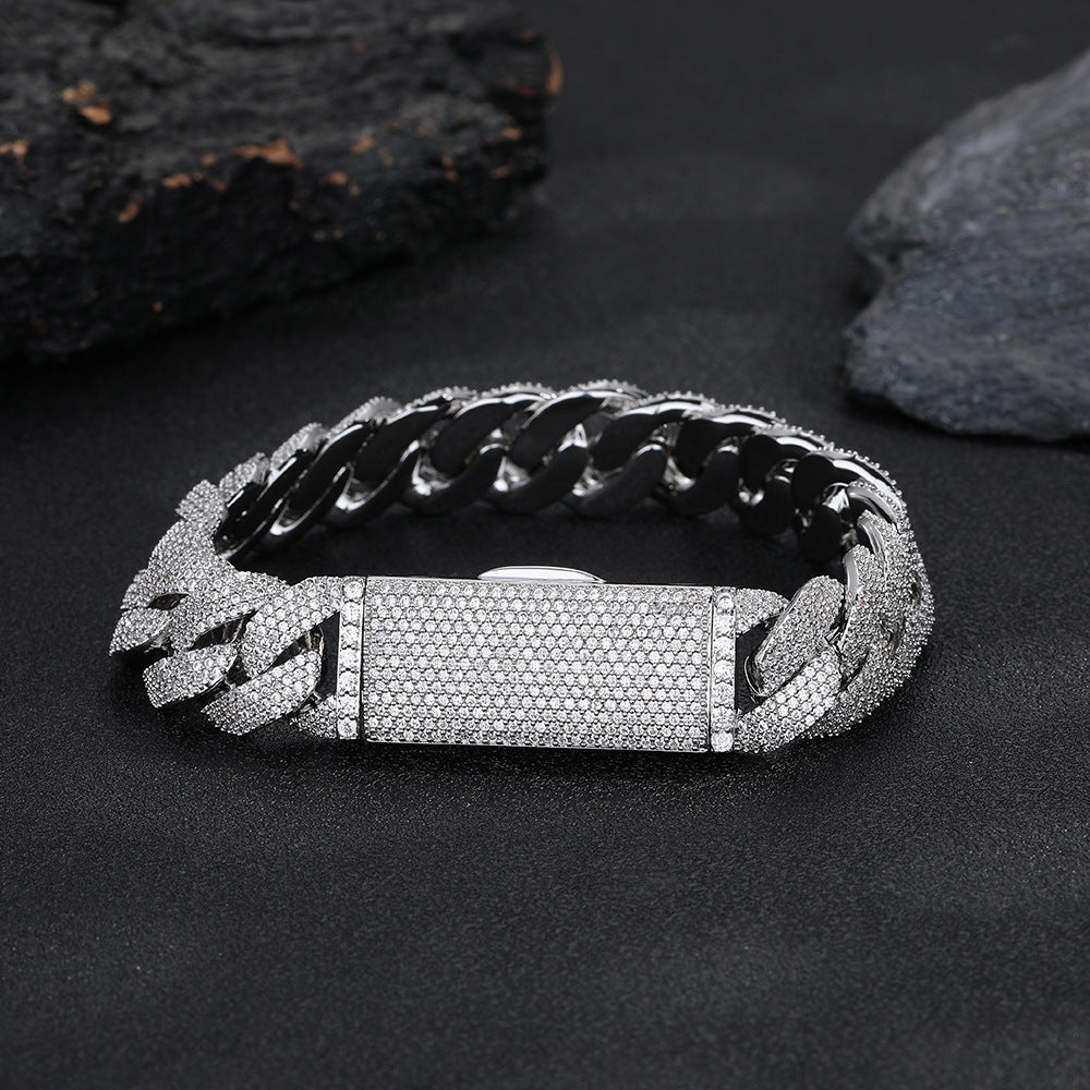 Silver-tone pavé Cuban bracelet with its box clasp closed on dark stone