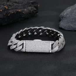 Silver-tone pavé Cuban bracelet with its box clasp closed on dark stone