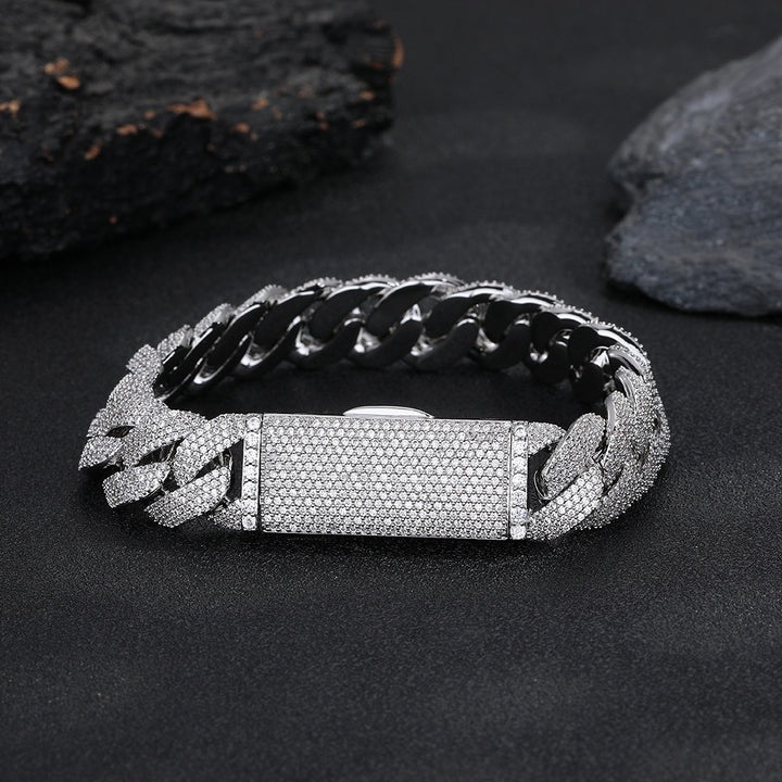 Silver-tone pavé Cuban bracelet with its box clasp closed on dark stone