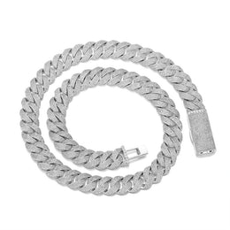 Silver-tone pavé Cuban chain coiled on white with its clasp open