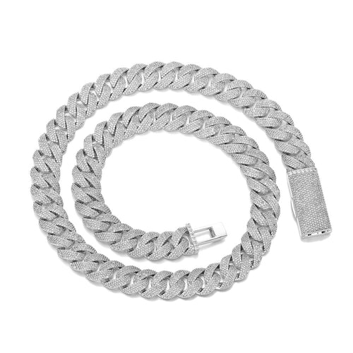 Silver-tone pavé Cuban chain coiled on white with its clasp open