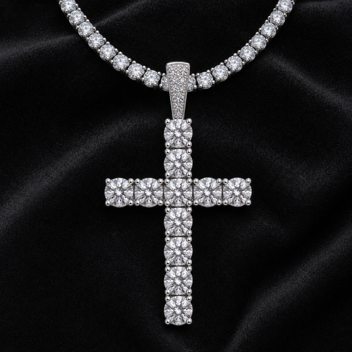 Silver-tone stone-set cross pendant on a tennis chain against black fabric