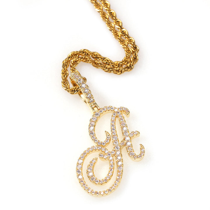 Gold-tone cubic zirconia script letter A pendant on white