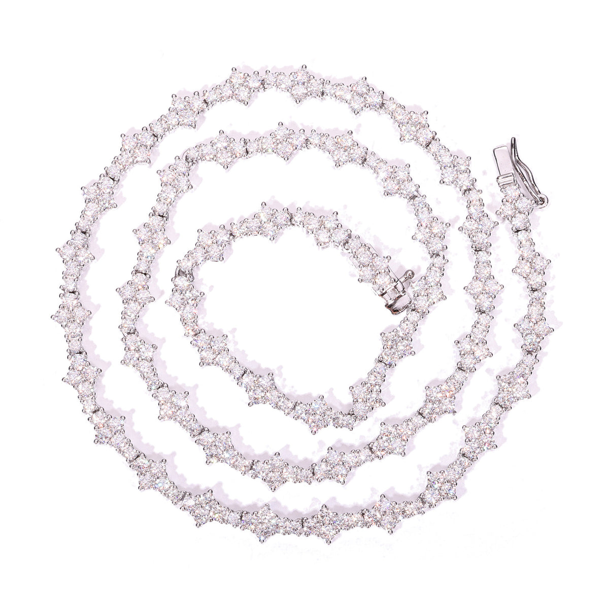 Silver-tone moissanite tennis chain coiled on white with its clasp visible