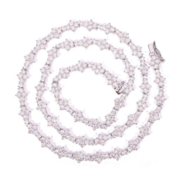 Silver-tone moissanite tennis chain coiled on white with its clasp visible
