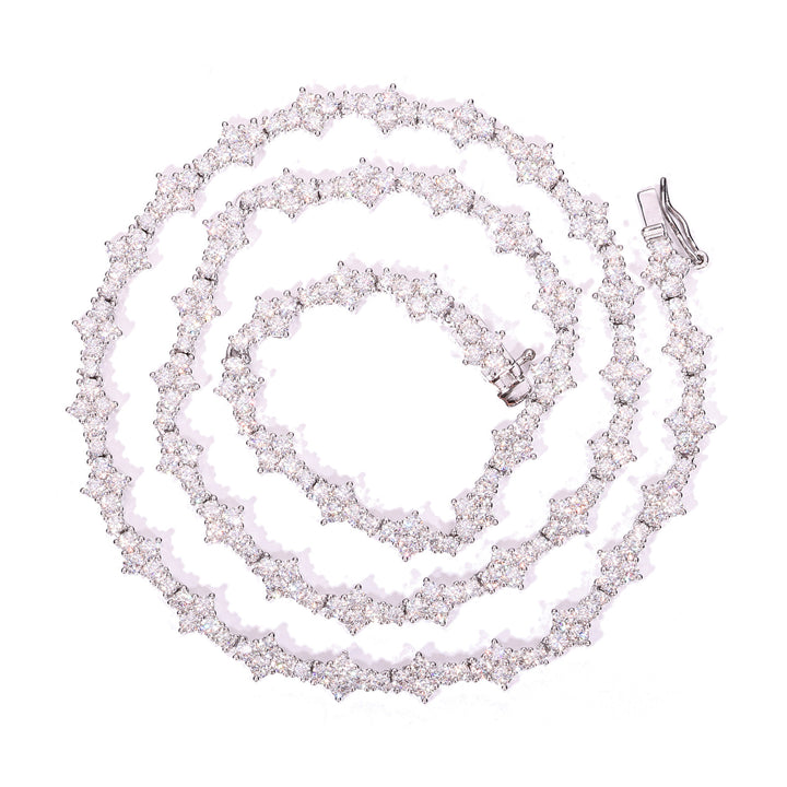 Silver-tone moissanite tennis chain coiled on white with its clasp visible