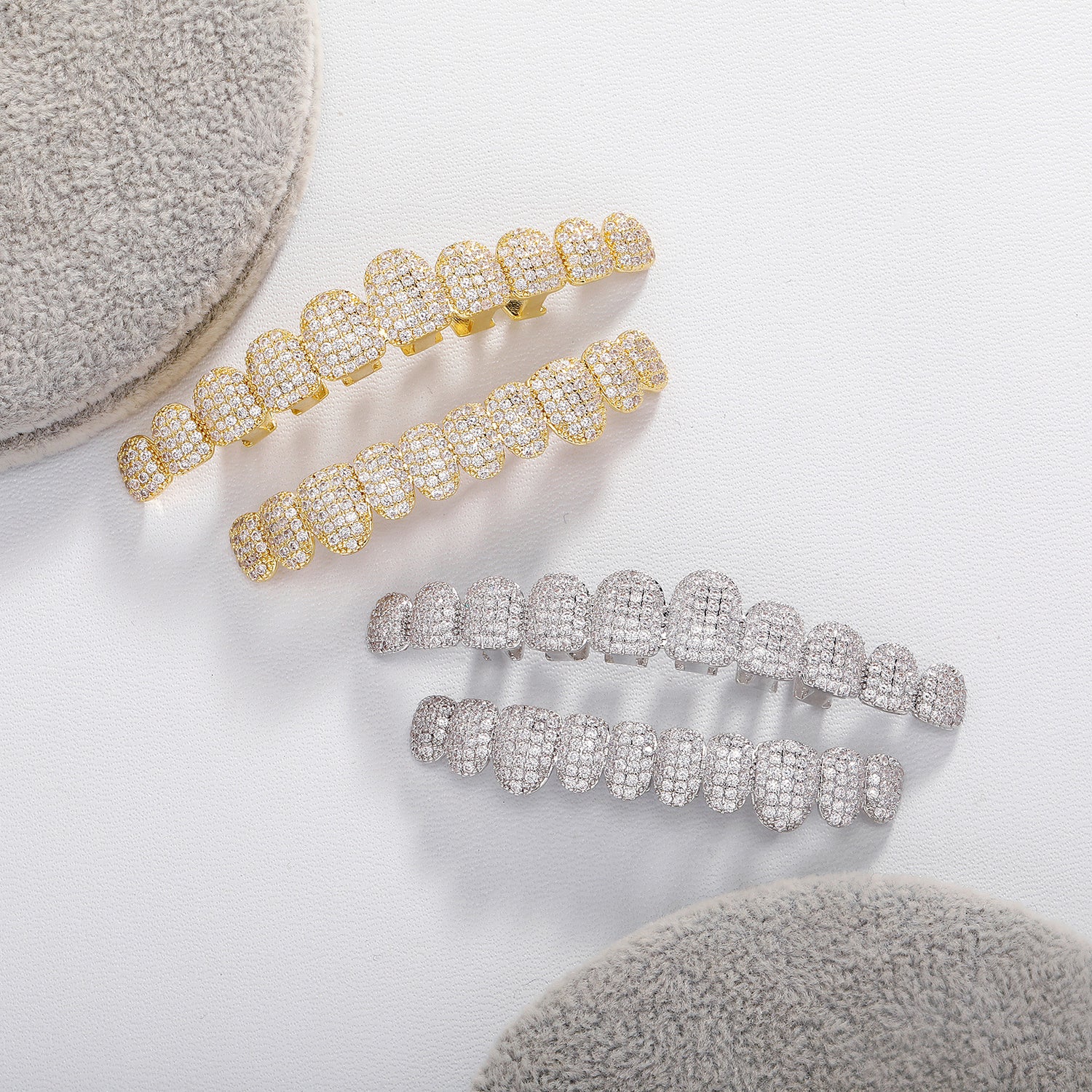Silver and Gold 10-tooth micro-pavé CZ grillz on white fabric