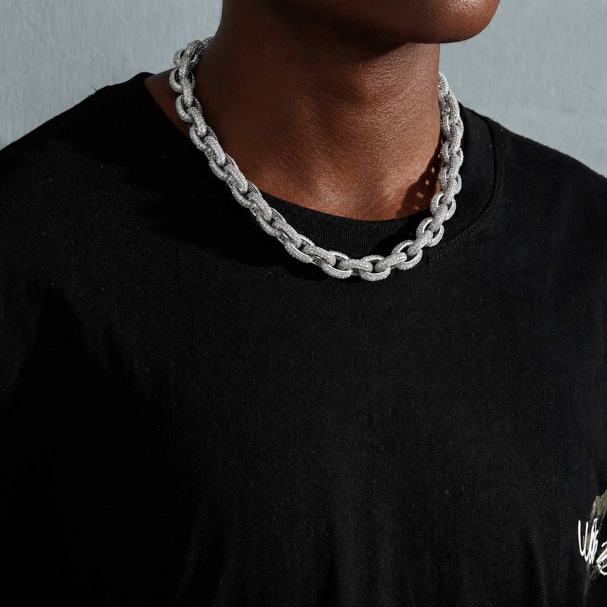 Silver iced O-link chain on a deep-brown model from an angled view