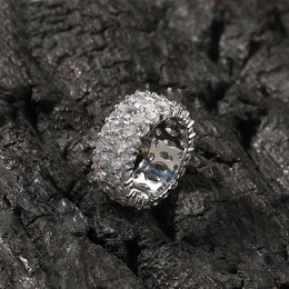 White-stone three-row oval ring displayed on black rocks
