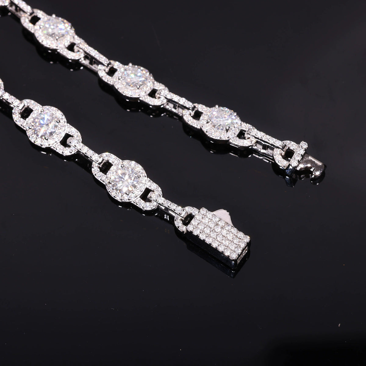 Close-up of round moissanite halo links, narrow connectors and stone-set box clasp