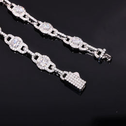 Close-up of round moissanite halo links, narrow connectors and stone-set box clasp