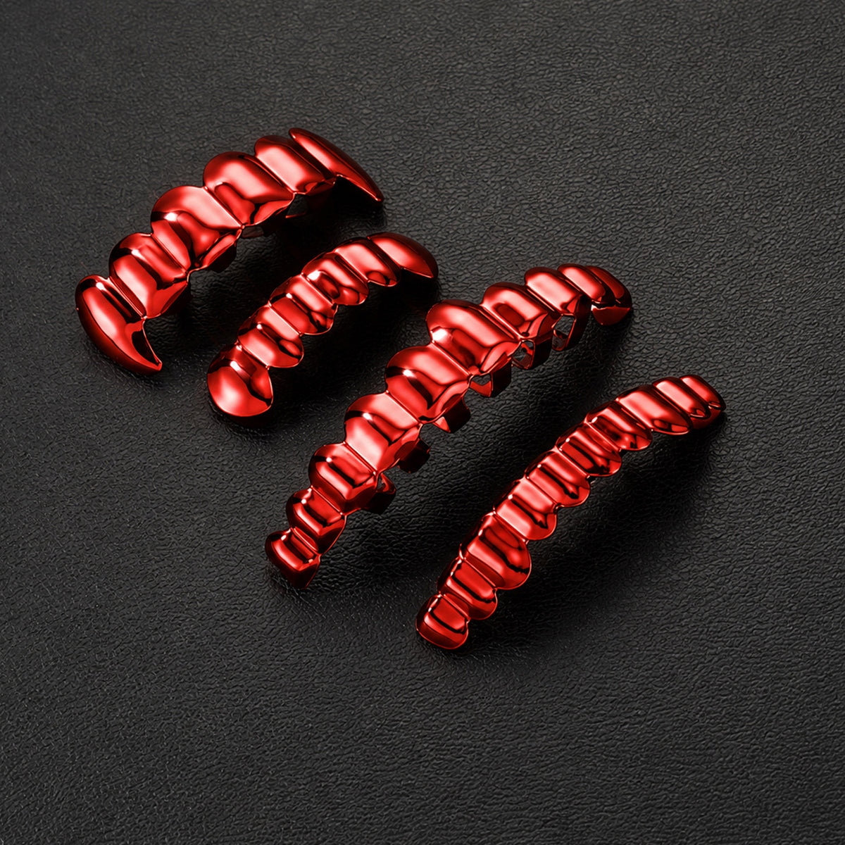 Red grillz in different widths arranged on a dark textured surface
