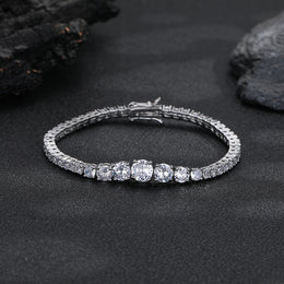 Silver-tone graduated tennis bracelet with its clasp closed on a dark surface