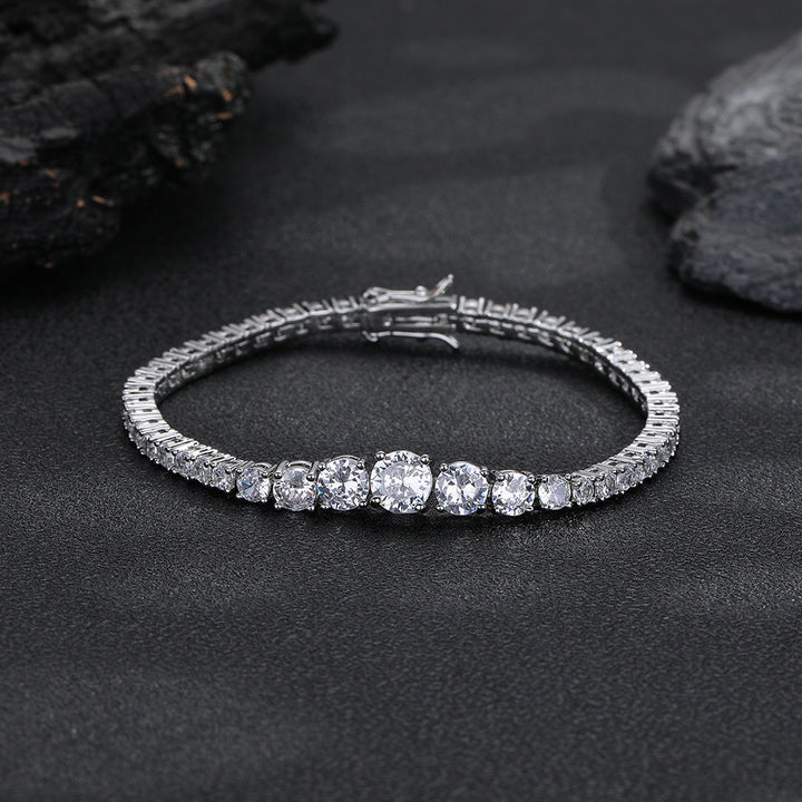 Silver-tone graduated tennis bracelet with its clasp closed on a dark surface