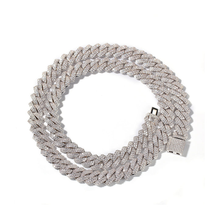 Silver-tone stone-set Cuban link necklace coiled on white