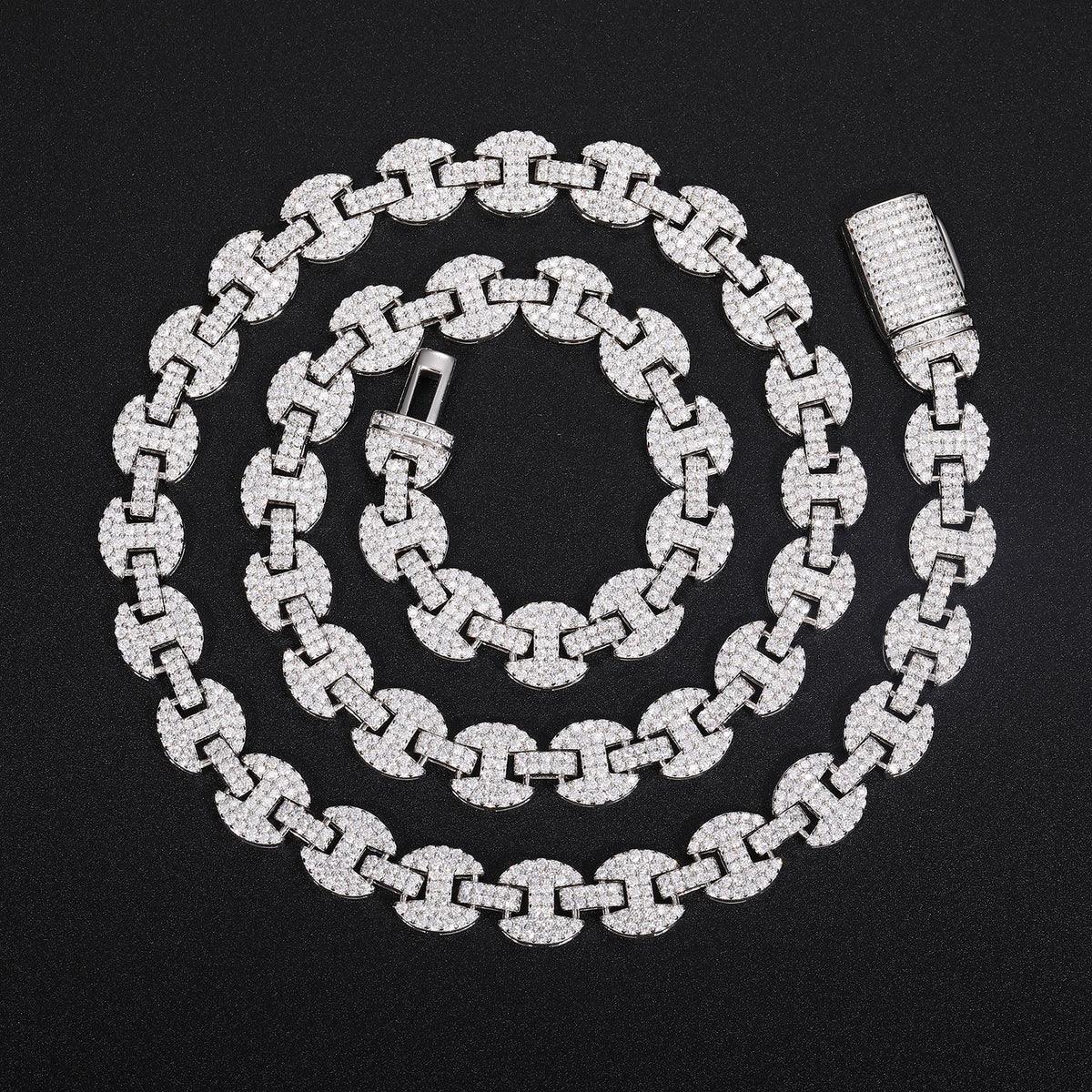 Silver-tone moissanite mariner chain in a spiral with its open clasp on black fabric
