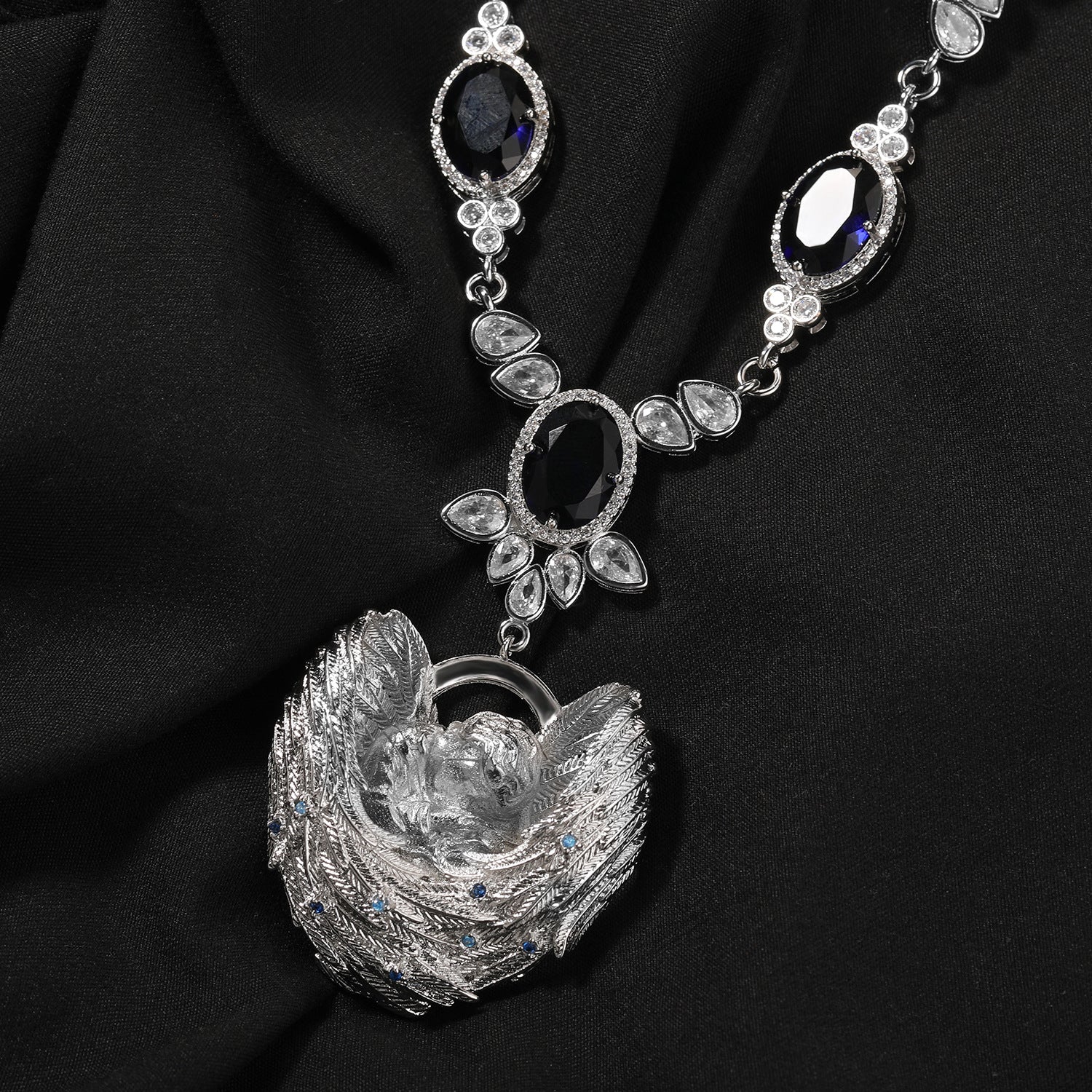 One-piece silver angel and wings Cupid necklace with sapphire-blue stones on black fabric