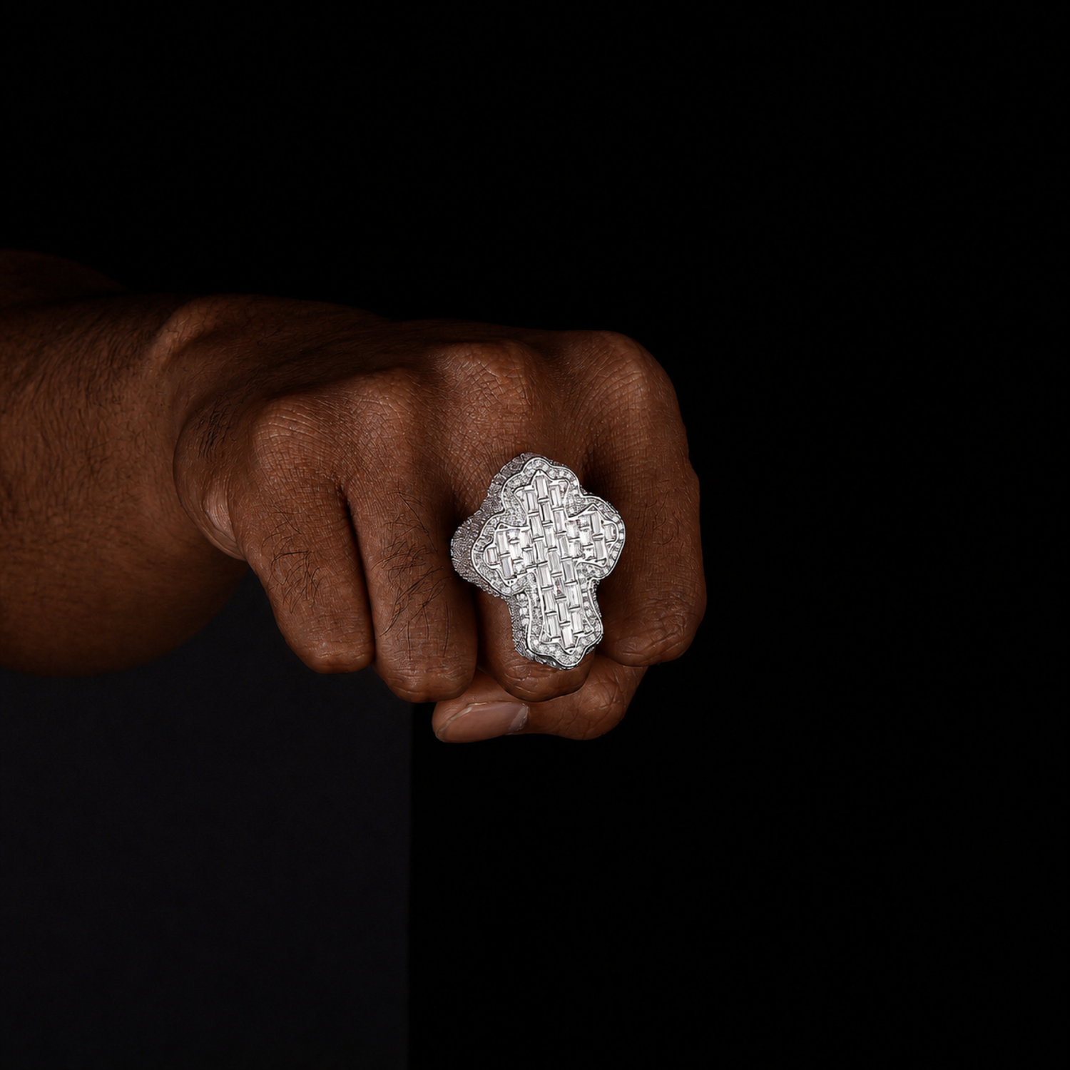 Silver 40mm cross statement ring worn by a deep-brown-skinned model