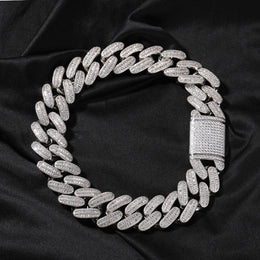 Silver 26mm iced baguette Cuban chain coiled on black fabric