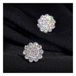 Silver flower moissanite stud earring pair on black fabric