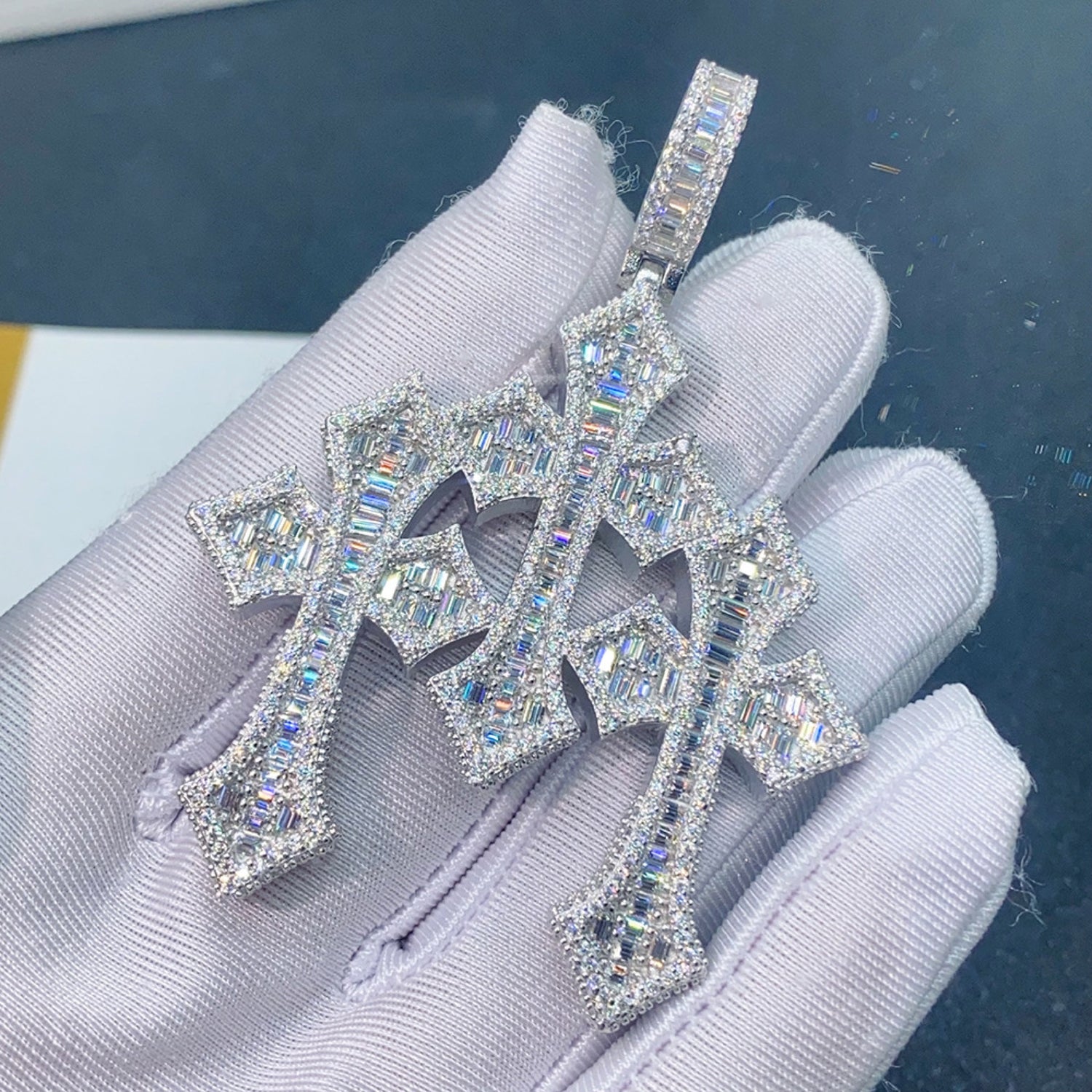 Silver triple Gothic Moissanite cross pendant held in white glove