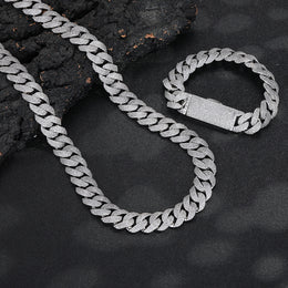 Silver-tone pavé Cuban chain and bracelet arranged on dark stone