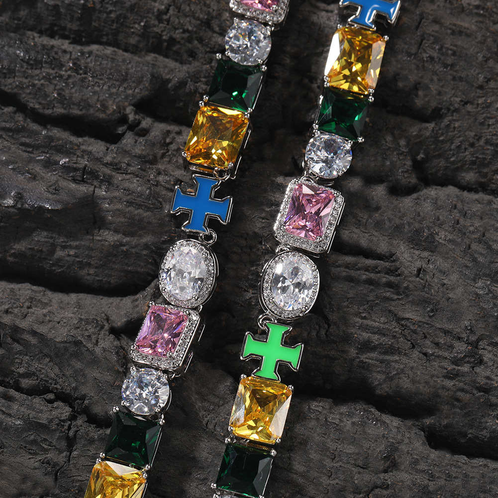 Close-up of multicolor faceted stones and blue and green cross links on dark rock