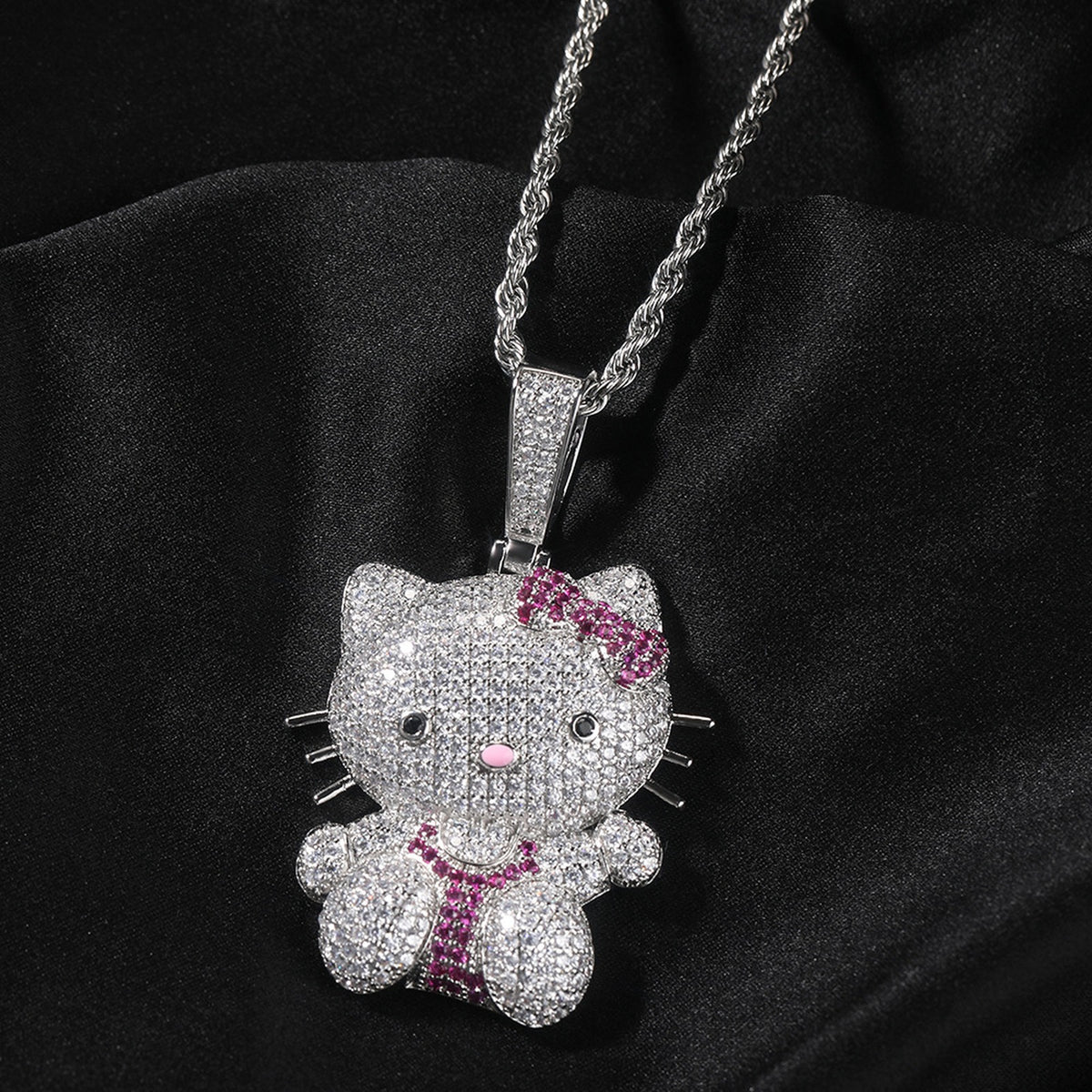 Silver iced pink bow cat pendant styled on black fabric