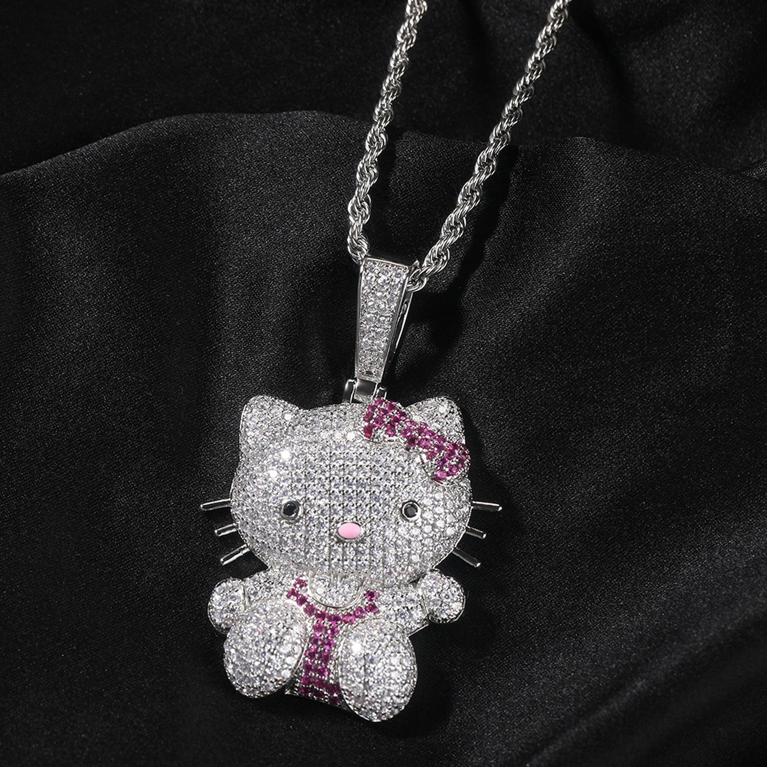 Silver iced pink bow cat pendant styled on black fabric