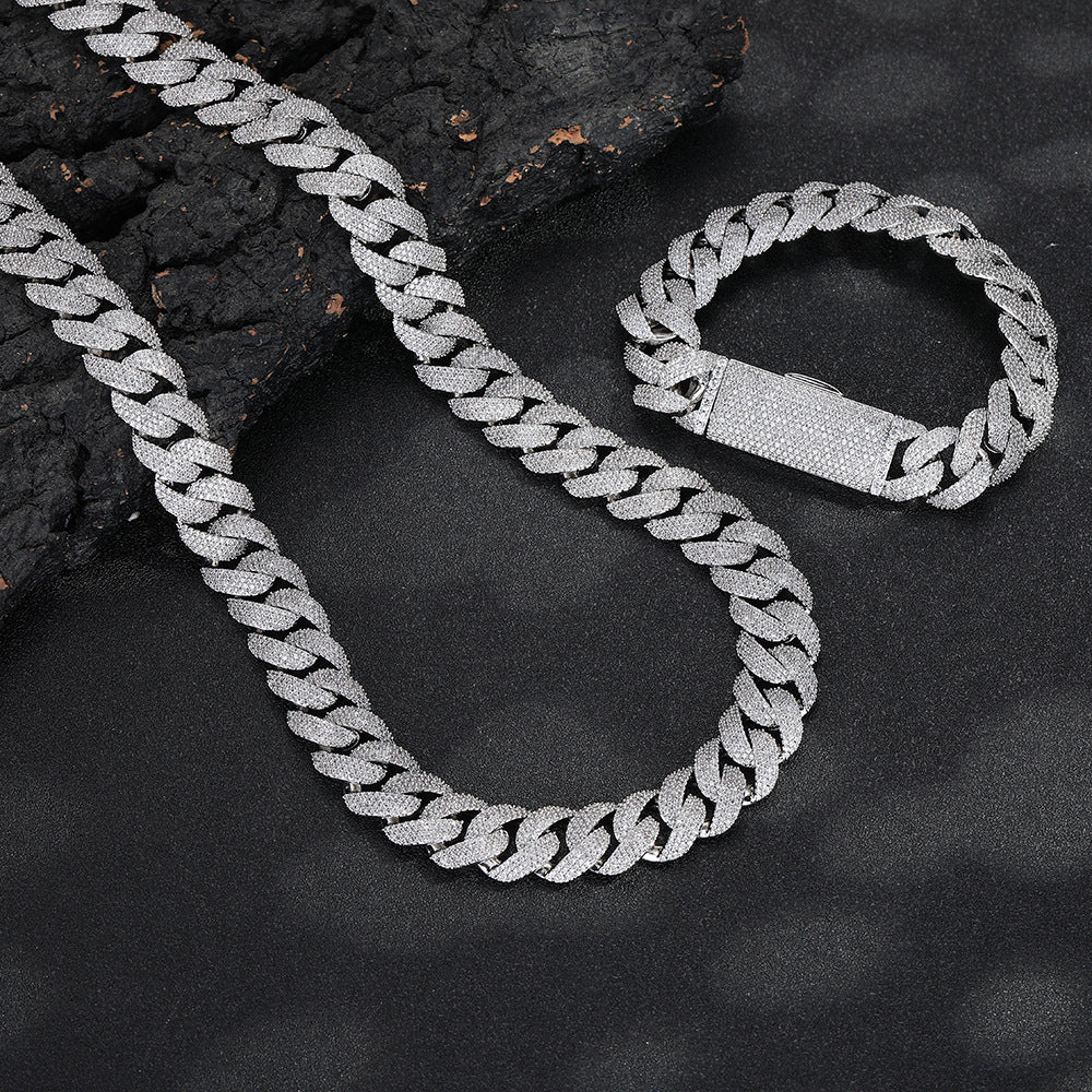 Silver-tone pavé Cuban chain and bracelet arranged on dark stone