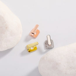 Rose Gold, Gold and Silver bar tooth caps arranged between pale stones