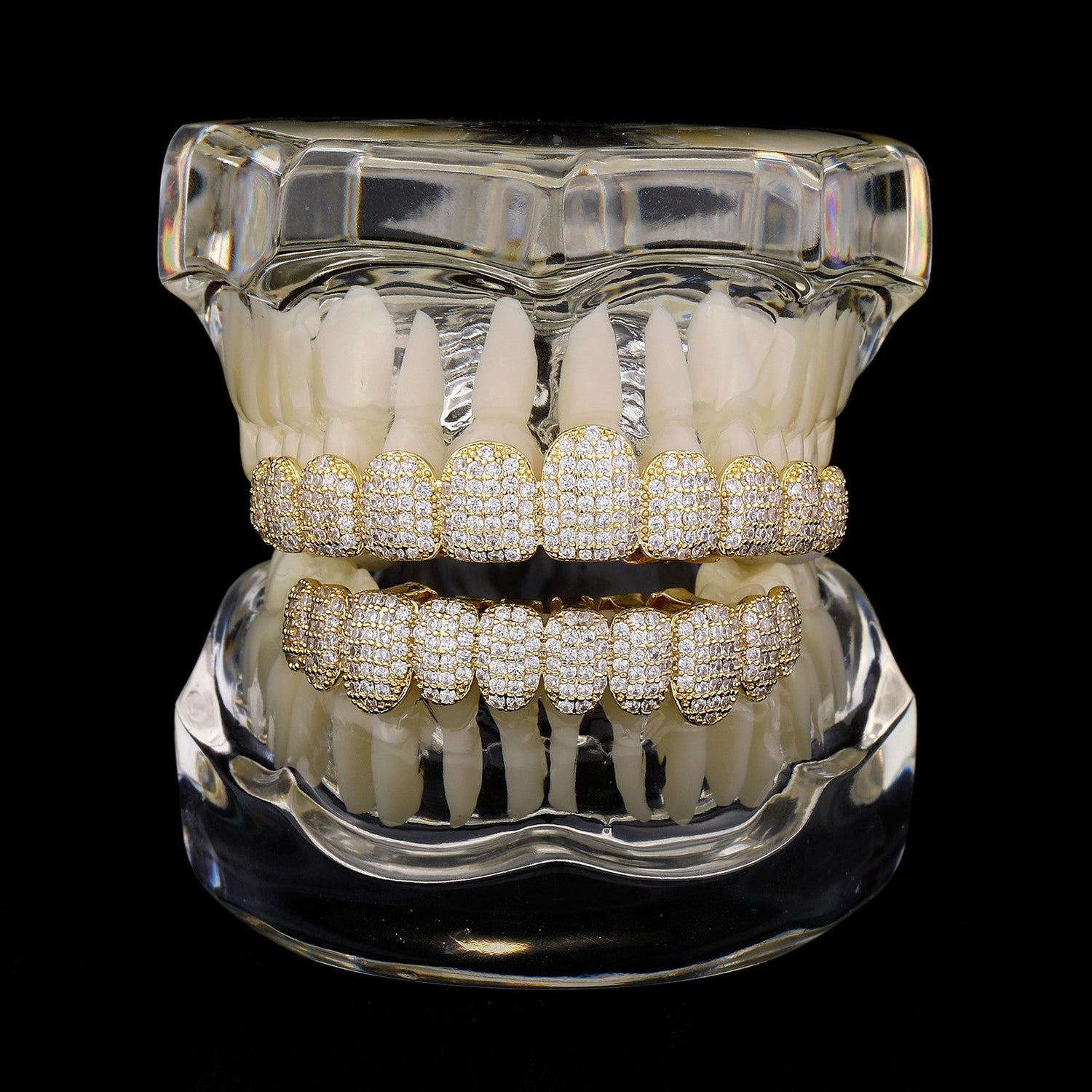 Gold micro-pavé CZ upper and lower grillz on a dental display model